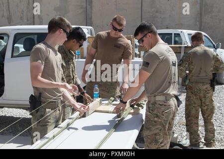 Soldaten in die 824Th Quartermaster Firma zugewiesen, 136 Bekämpfung Sustainment Support Battalion, 1. Panzerdivision der entschlossenen Unterstützung Sustainment Brigade, pack ein G-14 cargo Fallschirm für eine harte Druckabfall in Kandahar Air Field, Afghanistan Juni 15. Stockfoto