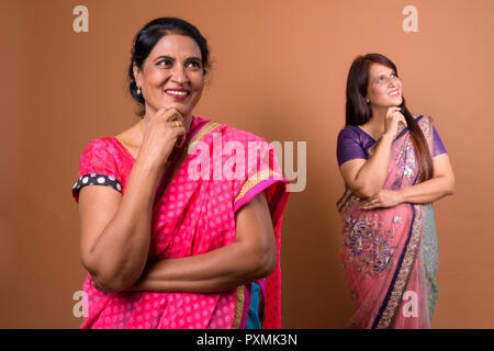 Zwei glückliche indische Frau denken und lächelnd Stockfoto