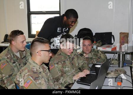 FORT GEORGE G. Meade, Maryland - Team Unfreundlichkeit, bestehend aus Sgt. Brandon Bushnell, Kapitän des Teams, SPC. Elia Harmon, SPC. Nicholas Cranston, und Pfc. Elia Frederickson, der 742Nd Military Intelligence (MI) Battalion, 704Th MI Brigade, sind hier mit dem Veranstalter, Sgt. 1. Klasse Terrance Smith (stehend), Echo, 782Nd MI Bataillon, mit deren technischen cyber Fähigkeiten und Teamarbeit zu "Capture the Flag", durch ein simuliertes Netzwerk einzudringen. Das Team gewann die 2017 CyberTitan Herausforderung II Wettbewerb, der hier stattfand, am 16. Juni. Stockfoto