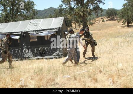 Soldaten der 357 Military Police Company, 200 Militärpolizei move Befehl zivile Rolle Spieler während eines simulierten gas Angriff auf Fort Hunter Liggett, Calif., 16. Juni 2017 zur Sicherheit. Mehr als 3000 US-Army Reserve Soldaten beteiligen sich an der 84. Krieger Ausbildung Befehl Übung (Warex) 19-17-03 am Fort Hunter Liggett, Calif.; die Warex ist eine groß angelegte kollektive Training Plattform fähig, tödliche generieren und bereit, Kräfte zu bekämpfen. Stockfoto