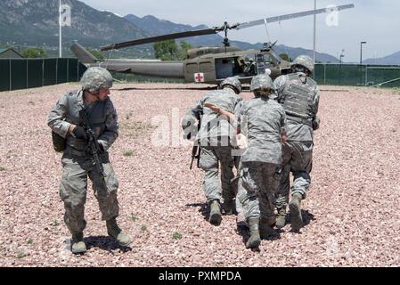 Technische Sgt. David Jacobson (links) eine Sicherheitskräfte personal Truppe und Technischen Sgt. Jonathan Harris, ein Raum, Operator und Kapitän Amber Knuthson, ein Arzt, der Assistent, alle aus dem 233 d Raum Gruppe, Rush eine simulierte Opfer unter Schutz von einem anderen Sicherheit Sicherheit Kräfte Truppe während einer Selbst-Hilfe/buddy - Pflege Ausbildung Szenario als Teil eines Feldes. Die 233 d Raum Gruppe ihre Fähigkeit, in strenge Bedingungen zu überleben und während ihrer jährlichen Feld Training in Fort Carson Army Installation betreiben, ist die Verbesserung, Colorado Springs. Sie sind der USAF nur mob Stockfoto