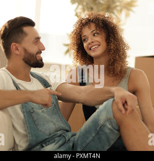 Glückliches Paar sitzt neben Boxen für Verschieben Stockfoto