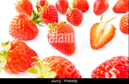 Nahaufnahme von frischen, lebendigen Erdbeeren mit grünen Stengeln auf weißem Hintergrund. Stockfoto