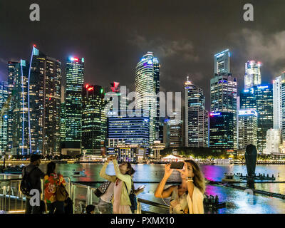 Touristen, die in Singapur Marina Bay fotografieren und selfies vor der Skyline der Stadt. Stockfoto