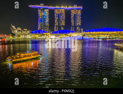 Ansicht bei Nacht in Singapur Marina Bay in Richtung der beleuchteten Marina Bay Sands Hotel. Stockfoto