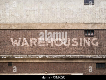 Alte Mauer in Rotterdam mit dem Wort "Warehousing" malte auf es Stockfoto