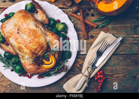 Thanksgiving gebratenes Huhn mit Rosenkohl und Gewürze auf einem rustikalen Holztisch. Thanksgiving Dinner oder fallen Abendessen Konzept Hintergrund mit aut Stockfoto