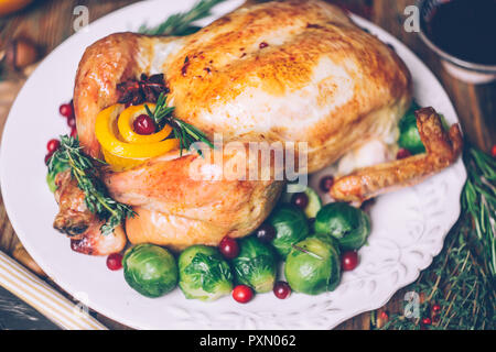 Thanksgiving gebratenes Huhn mit Rosenkohl und Gewürze auf einem rustikalen Holztisch. Thanksgiving Dinner oder fallen Abendessen Konzept Hintergrund mit aut Stockfoto