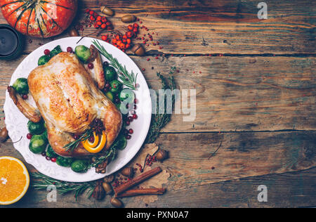 Thanksgiving gebratenes Huhn mit Rosenkohl und Gewürze auf einem rustikalen Holztisch. Thanksgiving Dinner oder fallen Abendessen Konzept Hintergrund mit aut Stockfoto