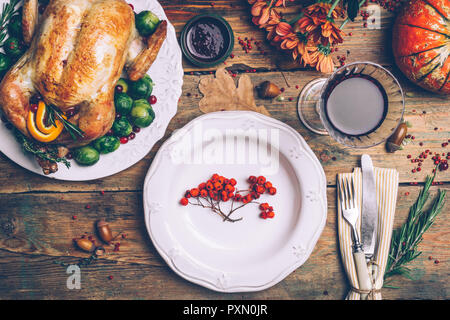 Thanksgiving gebratenes Huhn mit Rosenkohl und Gewürze auf einem rustikalen Holztisch. Thanksgiving Dinner oder fallen Abendessen Konzept Hintergrund mit aut Stockfoto