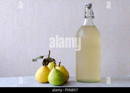 Birnen und Saft in einer Flasche auf hellen Hintergrund Stockfoto