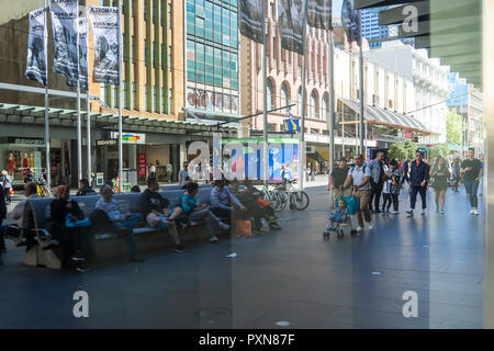 Einen Moment in der Zeit, in eine Stadt erobert als Reflexionen von mehreren Menschen über ihr Leben in einer verzerrten Sicht in einem Schaufenster gesehen werden Stockfoto