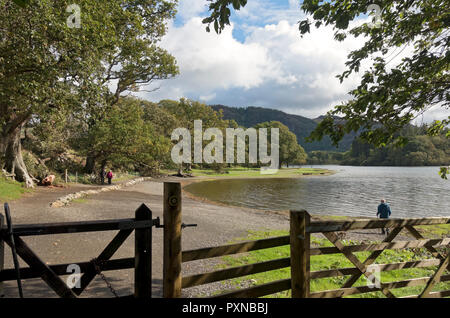 Menschen, die am Seeufer von Derwentwater in der Nähe von Keswick im Spätsommer laufen, Cumbria England Großbritannien GB Großbritannien Stockfoto