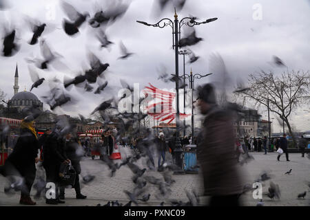 Istanbul, Türkei - 19 Februar 2018: Viele türkische Menschen vergehen von der Eminonu Square. Eine unscharfe Herde von Tauben fliegen. Stockfoto