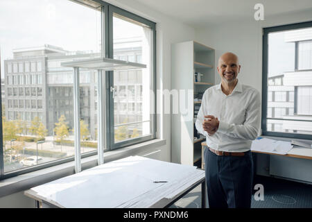 Erfolgreiche Ingenieur steht in seinem Büro Stockfoto