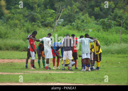 Donkorkrom, Ghana: 20. Juli 2016 - Junge Männer in einem Kreis betete vor ein Fußball Gewinnen in Ghana, Westafrika Stockfoto