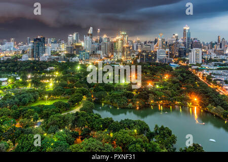 Lumpini Park und die Skyline der Stadt bei Dämmerung, Bangkok, Thailand Stockfoto