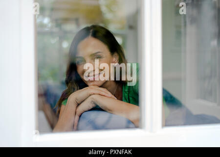 Portrait von lächelnden reife Frau auf der Couch zu Hause ausruhen Stockfoto