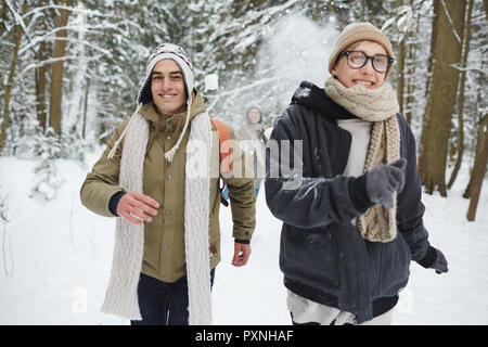 Portrait von glückliches junges Paar, das Spaß im Winter Wald und laufen in Richtung Kamera während der Ferien Stockfoto