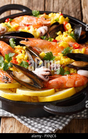 Nahaufnahme der traditionelle spanische Paella mit Meeresfrüchten in einer Pfanne auf dem Tisch. Vertikale Stockfoto