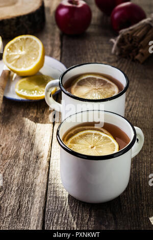 Heißen Tee mit Zitrone, Scheiben, Herbst und Winter gemütlich trinken auf rustikalen Holztisch Stockfoto