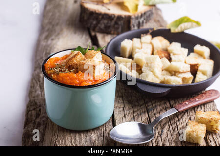 Herbst Kürbis Suppe auf hölzernen Tisch in ländlichen Tassen serviert, gesunde, vegetarische Mahlzeiten Stockfoto