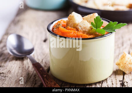 Herbst Kürbis Suppe auf hölzernen Tisch in ländlichen Tassen serviert, gesunde, vegetarische Mahlzeiten Stockfoto