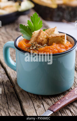 Herbst Kürbis Suppe auf hölzernen Tisch in ländlichen Tassen serviert, gesunde, vegetarische Mahlzeiten Stockfoto