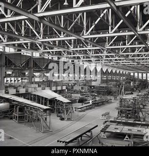 1950er Jahre, historische Bild, Flugzeuge gebaut wird oder innerhalb eines großen Bügel oder Fabrik, England, UK montiert. In den Vordergrund, kann man sehen, Teile der Flügel gebaut wird. Stockfoto