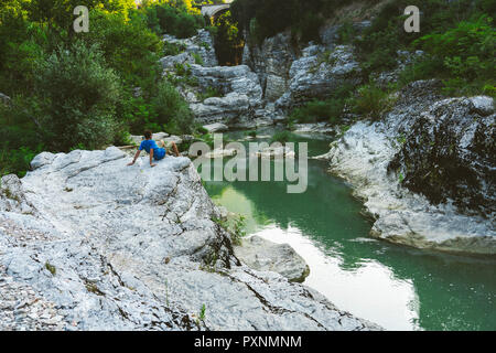 Italien, Marken, Fossombrone, Marmitte dei Giganti Canyon, Metauro Fluß, Wanderer sitzen auf Riverside Stockfoto