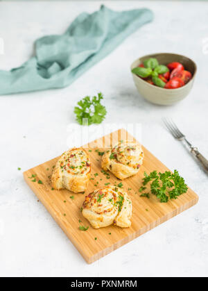 Sticky Buns mit Feta, Käse, Speck und Petersilie auf Holzbrett Stockfoto