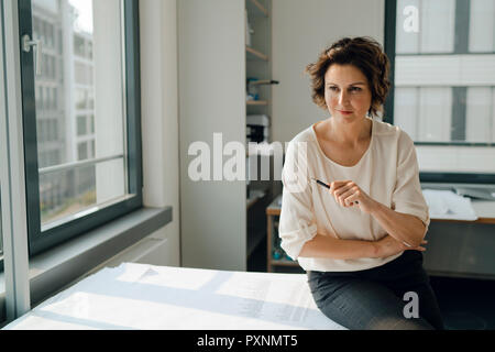 Geschäftsfrau im Büro, arbeiten auf Blueprints Stockfoto