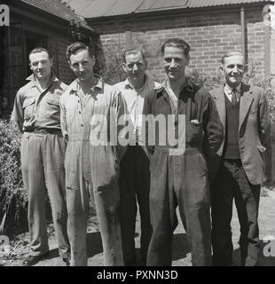 1950 s, historischen, einer Gruppe von reifen Fabrikarbeiter in Overalls und das Personal der Büros in ziviler Kleidung zusammen für ein Bild außerhalb, England, UK. Stockfoto