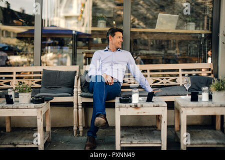 Unternehmer im Café sitzen, lächeln Stockfoto