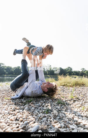 Vater und Sohn Spaß am Flußufer, Flugzeug Stockfoto