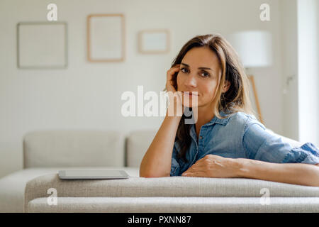 Porträt der reifen Frau auf der Couch zu Hause Stockfoto