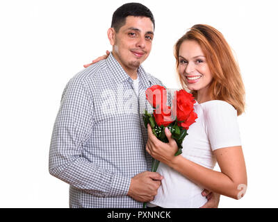 Junge glücklich Hispanic Paar lächelnd und in der Liebe mit roten Rosen Stockfoto