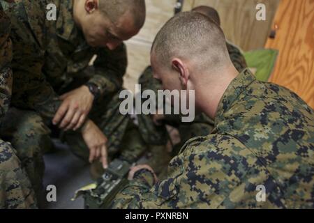 Us-Marines mit dem Befehl Element, Special Purpose Marine Air-Ground Task Force - Southern Command, erörtern, wie die Frequenzen auf die Armee, Marine/Tragbares Radio Communications zu programmieren - 117 Multiband manpack Radio im Soto Cano Air Base, Honduras, 15. Juni 2017. Radio Betreiber hielt einen zweitägigen Kurs um die Fähigkeiten der Marines mit Kommunikation Gang als Teil einer Infanterie Taktik Kurs verbessern. Stockfoto