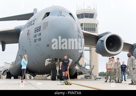 Cmdr. Grant Edwards, australische Bundespolizei, Botschaft von Australien, Washington, D.C., Linien, aus seinem Seil für Grip, der vor seinem zweiten Versuch bei Ziehen einer C-17 Globemaster III, 16. Juni 2017, auf Dover Air Force Base, Del Kate Lord, Edwards' Frau, Links, und Mitglieder der 736th 712Th und Flugzeugwartung Staffeln beobachtete Edwards, ein australischer strongman Athleten, versuchen Sie, den C-17 mit einem Gewicht von ca. 418,898 Pfund zu ziehen. Stockfoto