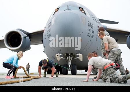 Aus dem Flight Deck, Master Sgt. Christine König, Oben links, und Tech. Sgt. Brinnae Wigley, Oben rechts, beide 712th Aircraft Maintenance Squadron crew Chiefs, Watch Cmdr. Grant Edwards, australische Bundespolizei, Botschaft von Australien, Washington, D.C., positioniert sich auf seinem dritten Versuch zu ziehen einer C-17 Globemaster III wiegt etwa 418,898 Pfund, 16. Juni 2017, auf Dover Air Force Base, Del Kate Lord, Edwards' Frau, Links, und die Mitglieder der 736th Aircraft Maintenance Squadron Beifall auf Edwards, ein australischer strongman Athleten, bei diesem Versuch. Edwards ist geplant, um zu versuchen, Stockfoto