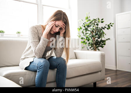 Portrait von Frau mit traurigen Blick auf das Wohnzimmer Stockfoto