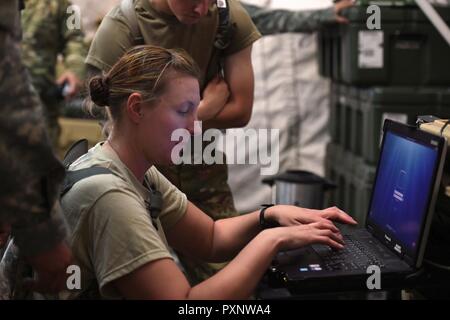 Sgt. Brandy Crenshaw, von Cheyenne, eine menschliche Ressourcen NCO auf die 115 Field Artillery Brigade zugeordnet, lernt wie der Controller für das Very Small Aperture Terminal System auf's Camp Guernsey Süd Ausbildung Bereich, in dem die betriebliche Ausbildung zu bedienen ist. Mehr als 1000 Wyoming Army National Guard Soldaten konvergieren auf Camp Guernsey gemeinsame Training Center in diesem Monat für ihre zwei Wochen jährliche Schulung Engagement und die öffentlichen Angelegenheiten Amt wird mit täglichen sozialen Medien Beiträge unserer Soldaten ihre Fähigkeiten im Juni. (Wyoming Armee Stockfoto