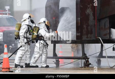 Staff Sgt. Logan Knutson und Flieger 1. Klasse Hannah Reichert, 81st Abteilung Infrastruktur Feuerwehrmänner, benutzen Sie ein in der Hand gehaltenes Schlauch ein Feuerwehrmann Ausbildungsbeihilfen während Live Fire übung auf der Flightline Juni 7, 2017 zu löschen, auf Keesler Air Force Base, Fräulein Der keesler Feuerwehr, die Gulfport CRTC Feuerwehr und der stennis Space Center Feuerwehr sind alle benötigten Flugzeuge Rettungs- und Brandbekämpfungsmaßnahmen zu üben eine halbjährliche Schulung Anforderung zu erfüllen. Stockfoto