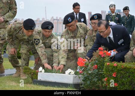 KATUSAs (Koreanische Augmentees in die United States Army) von der 194Th bekämpfen Sustainment Support Battalion, 2nd Infantry Division Sustainment Brigade, 2 Infanterie Division/Republik Korea-USA Kombinierte Division, Respekt für die Gefallenen während der jährlichen Gedenkfeier KATUSA bewirtet durch die Assoziierung der KATUSA Veteran. Die Zeremonie, die bei den Vereinten Nationen Friedhof jedes Jahr fand am 6. Juni in Busan, Südkorea, erinnert an KATUSA Soldaten, die im koreanischen Krieg und ihre Nachfolger enthalten. Stockfoto