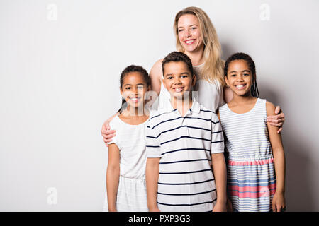 Caucassian Mutter mit schwarz Twin und Sohn Kind im Studio weiß Stockfoto