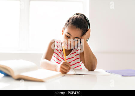 Ein niedliches schwarzes Mädchen Hausaufgaben zu Hause Stockfoto