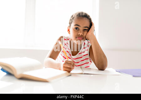 Ein niedliches schwarzes Mädchen Hausaufgaben zu Hause Stockfoto