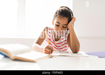 Ein niedliches schwarzes Mädchen Hausaufgaben zu Hause Stockfoto