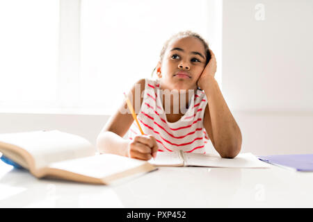 Ein niedliches schwarzes Mädchen Hausaufgaben zu Hause Stockfoto