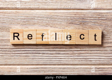 Reflektieren Wort auf Holz Block geschrieben. Spiegeln von Text auf dem Tisch, Konzept. Stockfoto